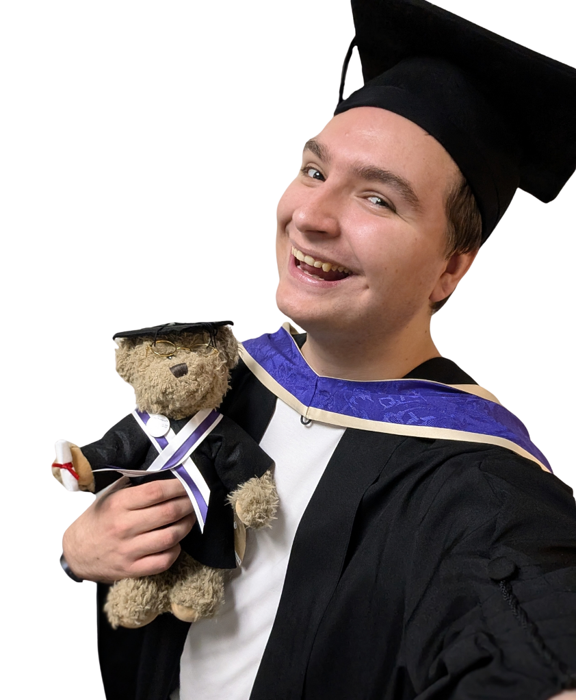 George at his graduation, holding a teddy bear in a matching gown